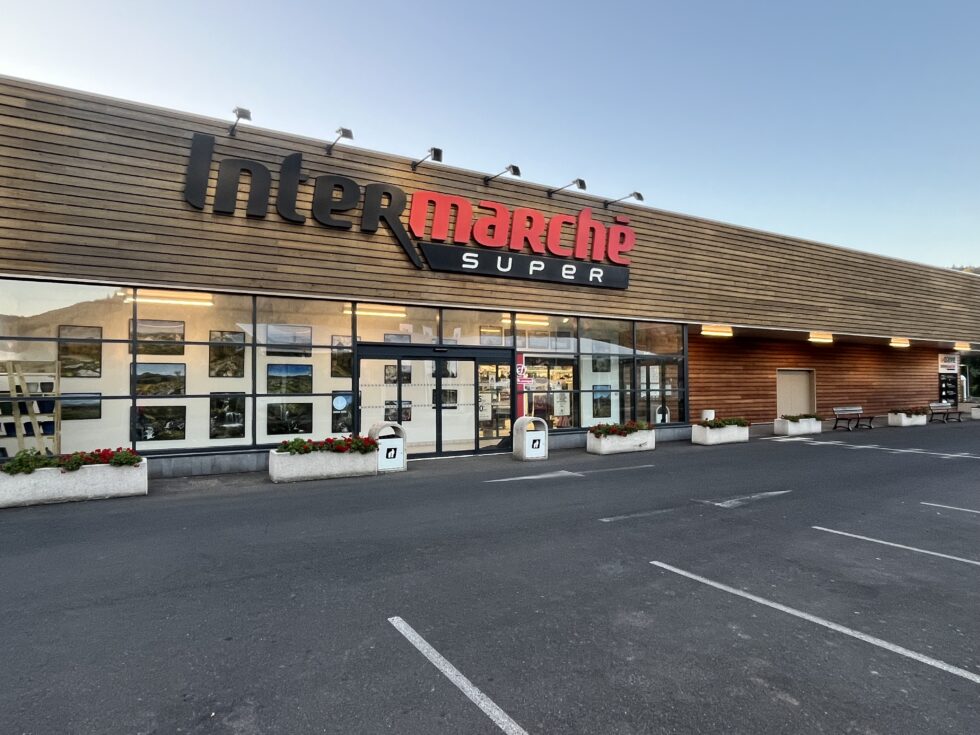 Travaux de rénovation et entretien d'un bardage extérieur vertical en bois d'un intermarché avec un saturateur haute performance