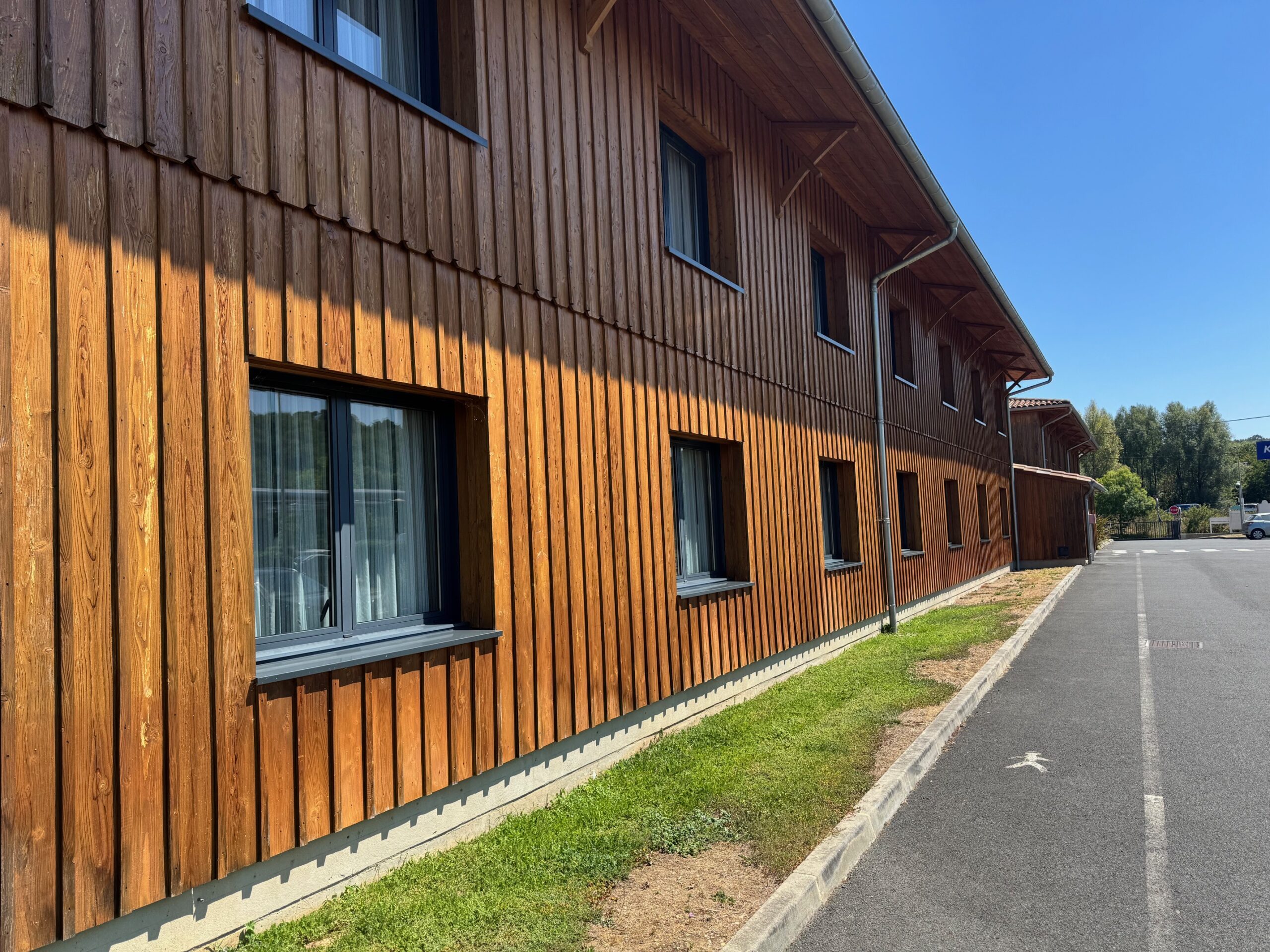 Application d'un saturateur ignifuge sur un bardage bois vertical d'un hôtel ERP 
